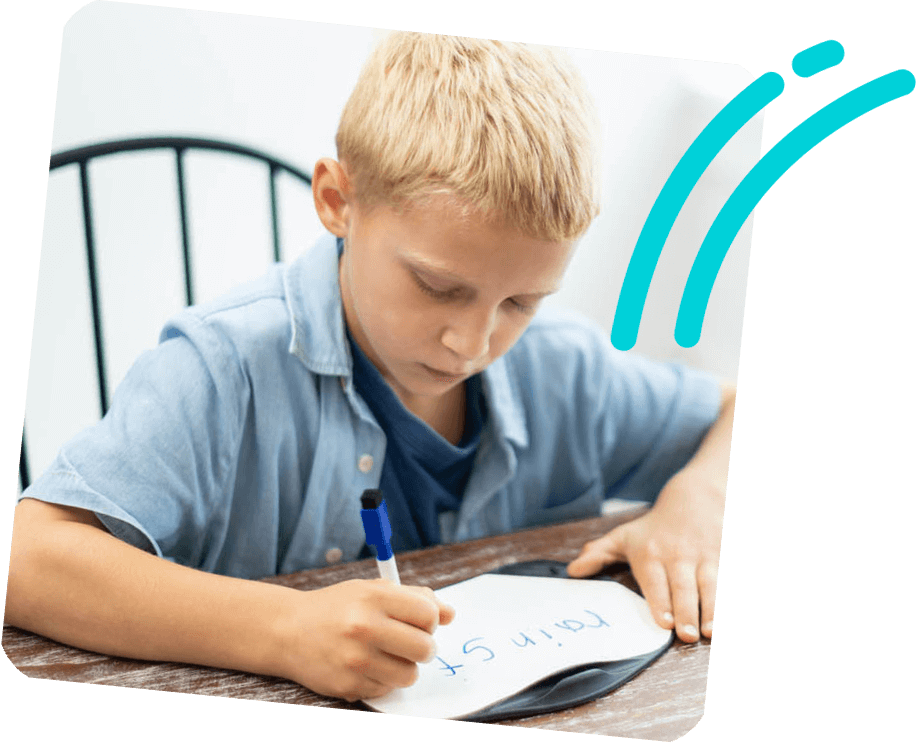 boy writing a word on a white board