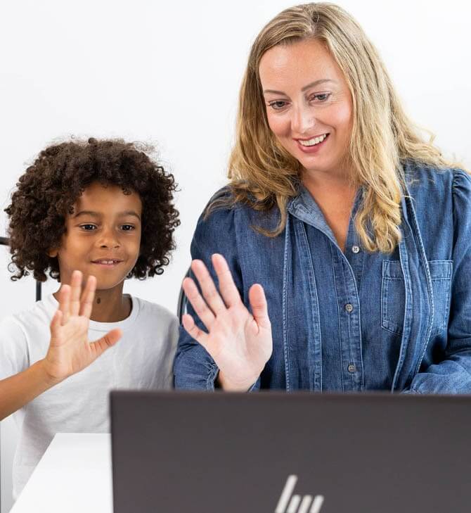 Woman and young girl wave at laptop after a tutoring session